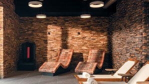 Un cuarto de spa con paredes de madera, tres sillones de masaje y una sauna.