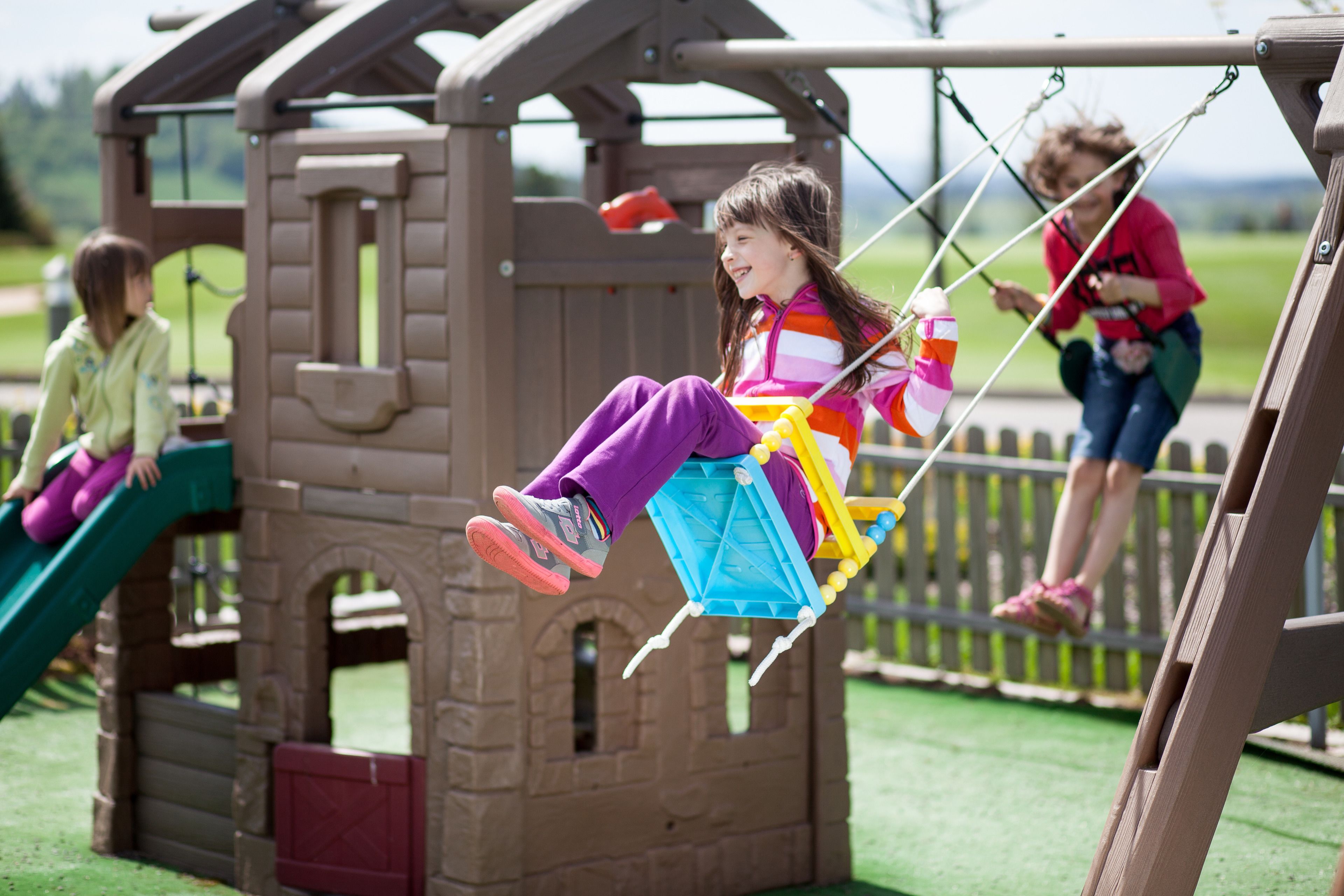 Un espace de jeux pour enfants avec une balançoire et un toboggan.