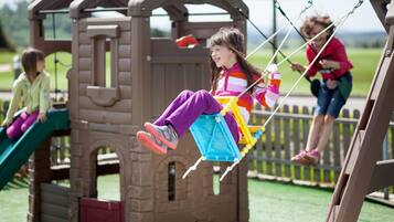 Un espace de jeux pour enfants avec une balançoire et un toboggan.
