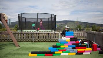 Un parque infantil con una estructura para escalar y una zona de juegos con red.