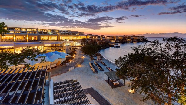 Un hotel con piscina, zona de estar al aire libre y vistas al mar.