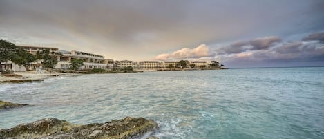 Un hotel frente al mar con vista a la costa rocosa.