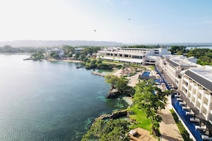 Um resort com piscina, praia e vista para a água.