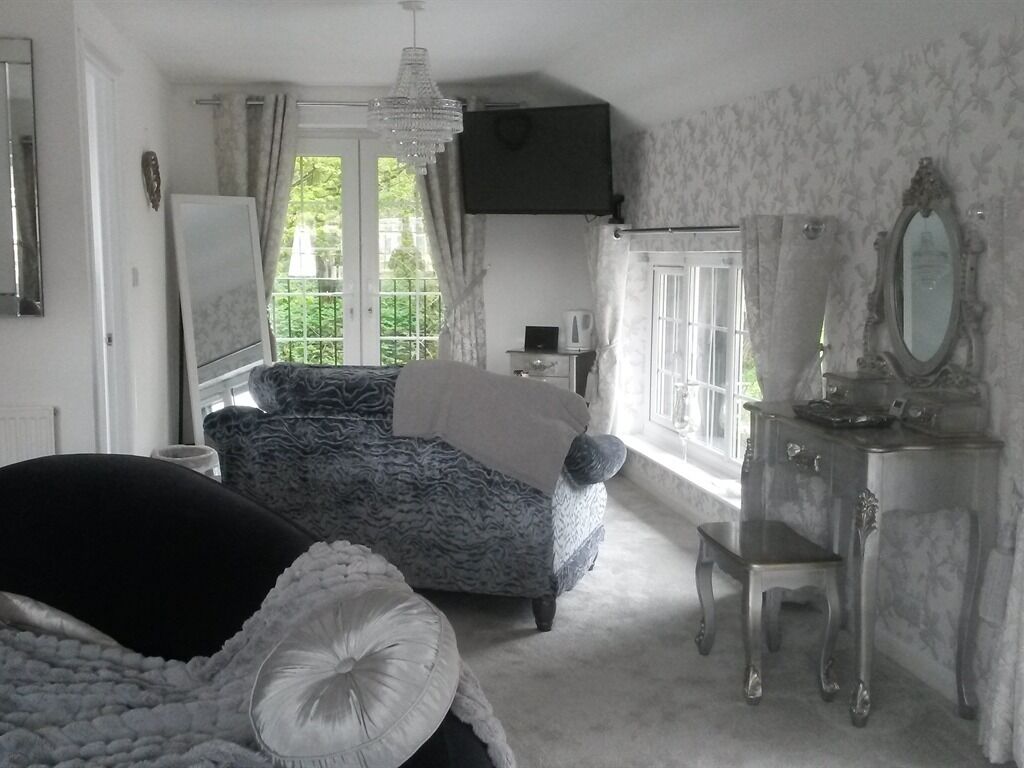 Un dormitorio con cama, cómoda, espejo y ventana con cortinas.