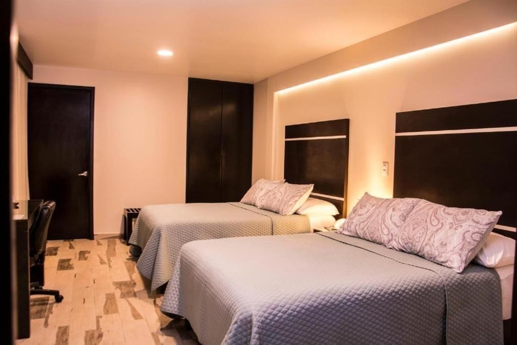 Habitación cuádruple Confort, 2 camas matrimoniales | Caja de seguridad en la habitación y escritorio 