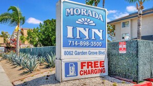 Señal de Morada Inn con un número de teléfono, dirección y comodidades como carga gratuita.