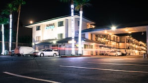 Un hotel de varios pisos con estacionamiento y una zona techada.