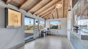 Un interior moderno con techo de madera, ventanas amplias y un mostrador de recepción.