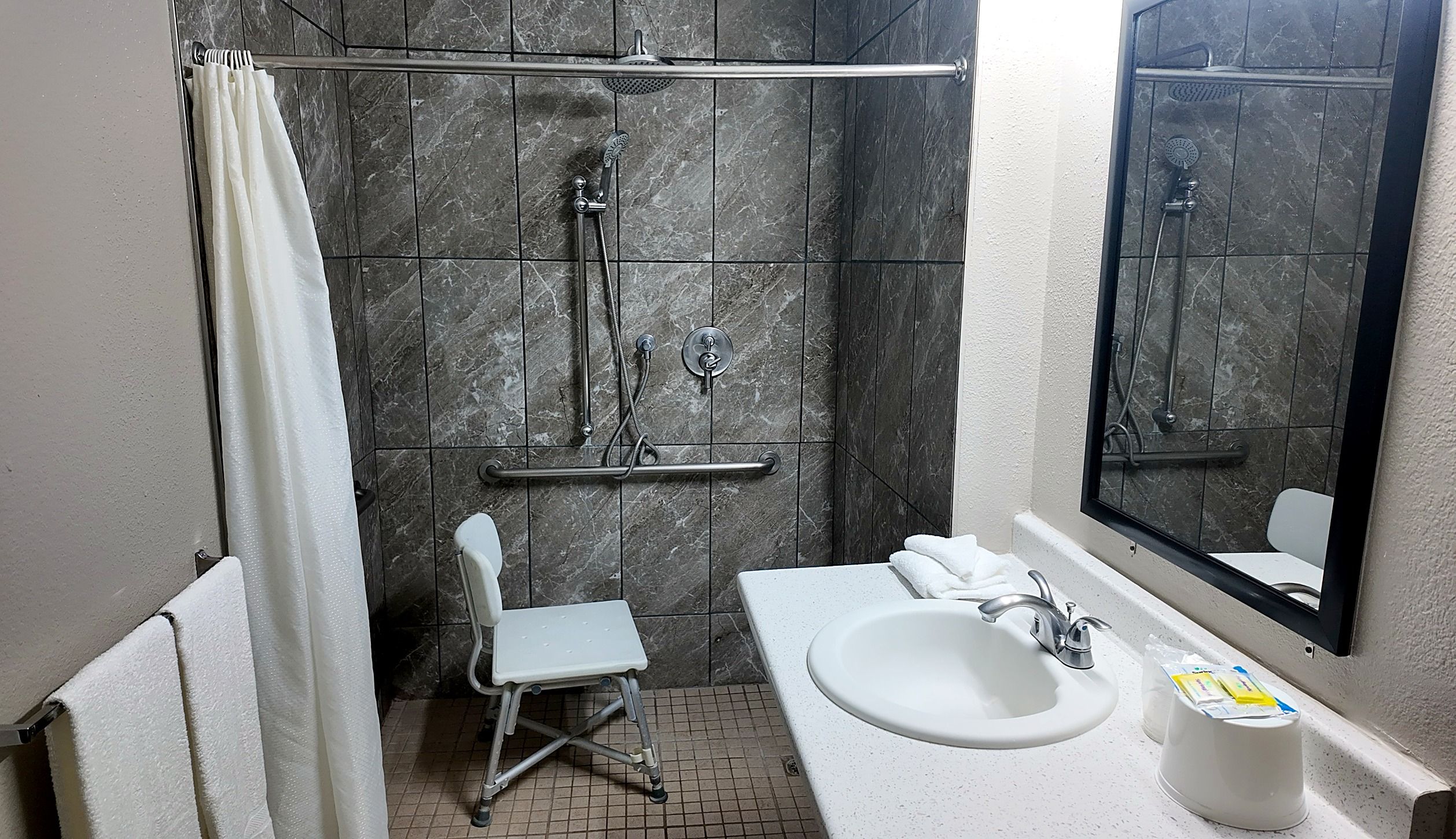 A bathroom with a shower, a toilet, and a sink.