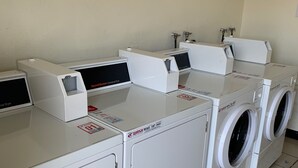 A laundry facility with multiple washing machines and dryers, including a Speed Queen brand dryer. - Morada Inn - Near Garden Grove Park (Garden Grove)