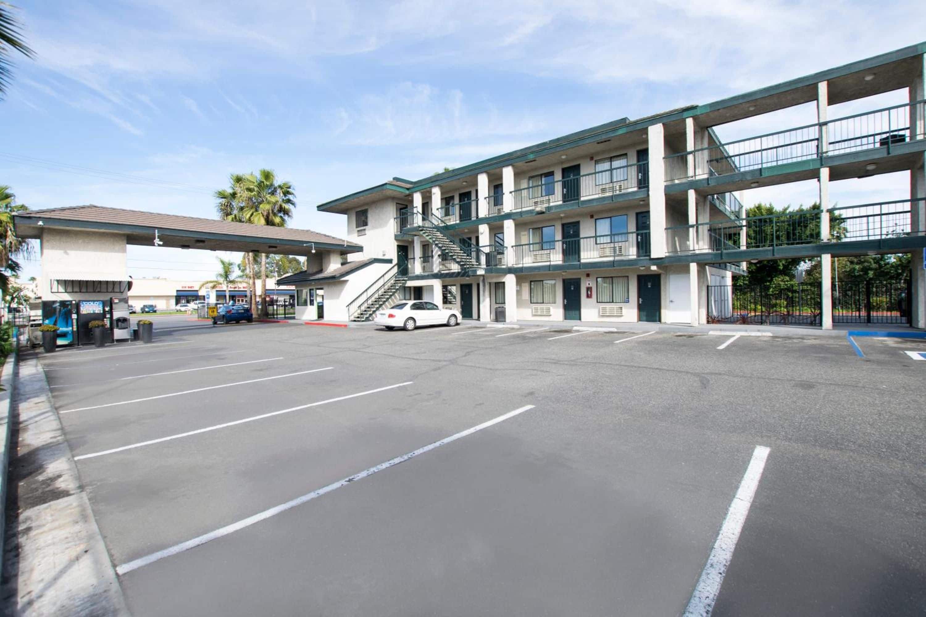 A multi-story parking garage with a white car parked in the lot.