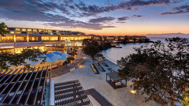 A resort with multiple buildings, a beach area with sun loungers, and a view of the sea. - Royalton Negril, An Autograph Collection All-Inclusive Resort (Negril)