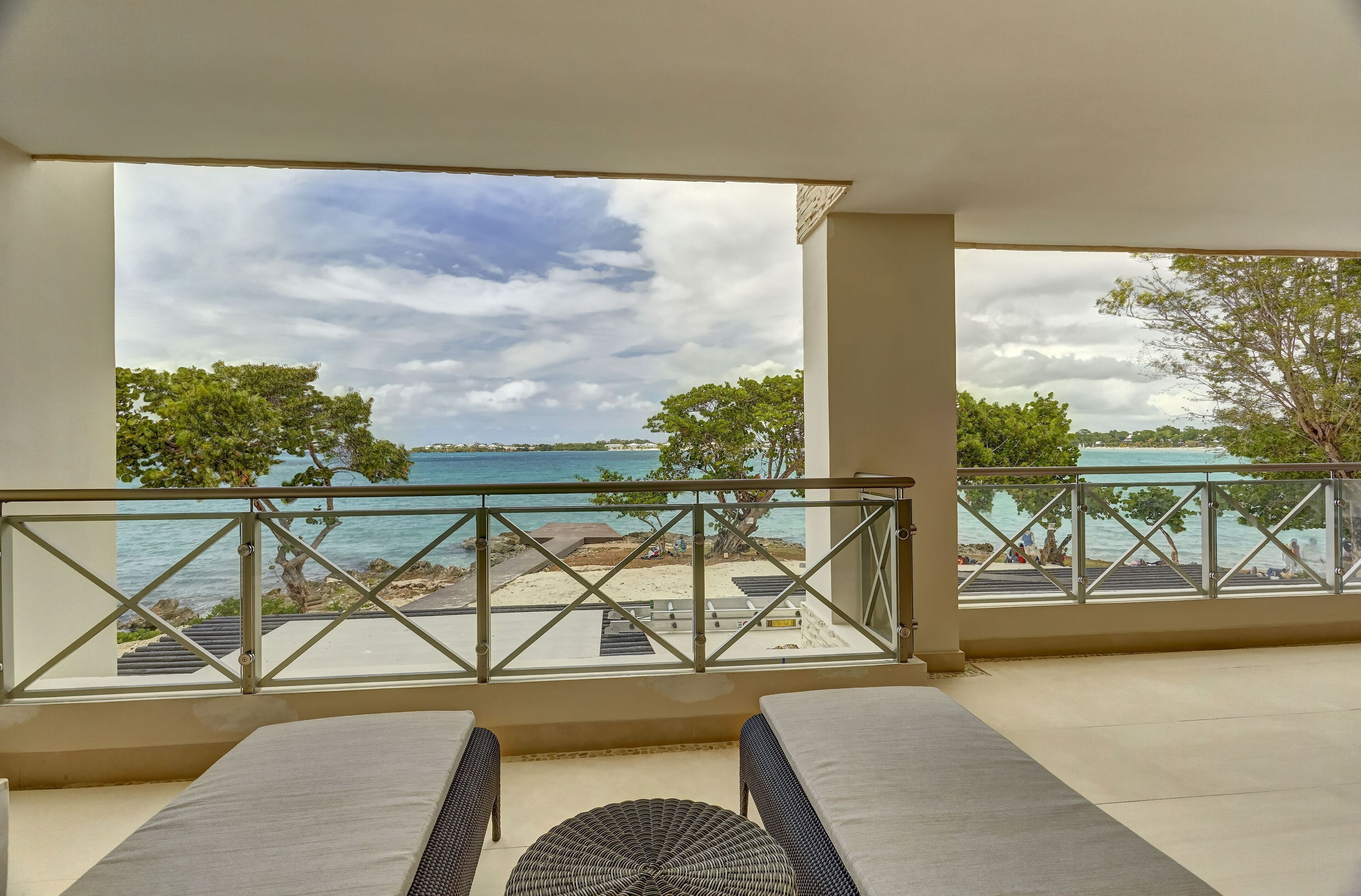 A balcony with a view of the beach and ocean.