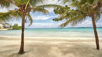On the beach, white sand, sun loungers, beach umbrellas