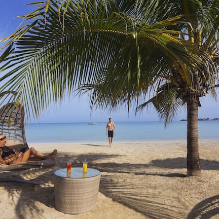 On the beach, white sand, sun loungers, beach umbrellas