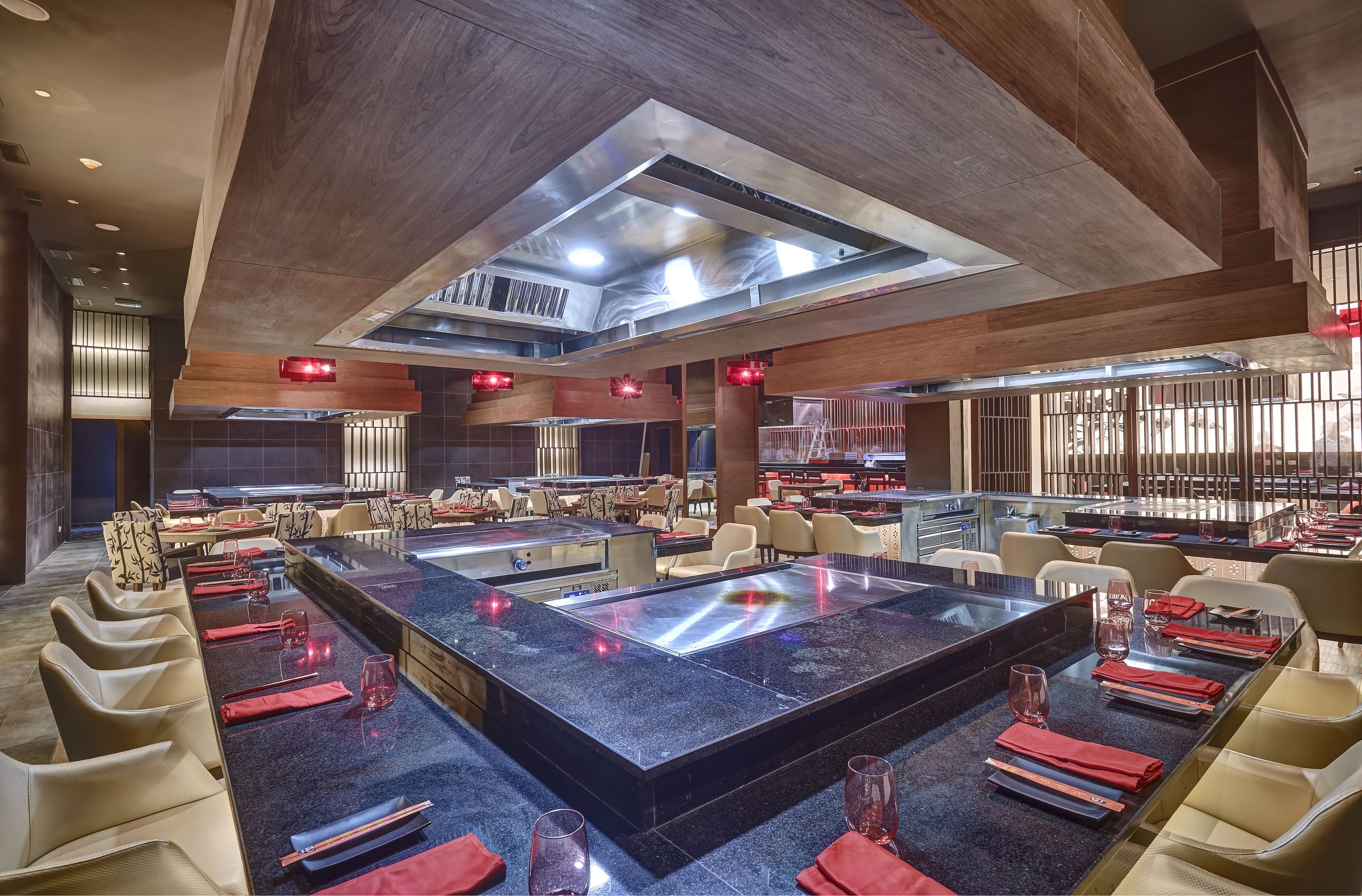 Un restaurante moderno con una isla central, techos altos y un diseño contemporáneo.