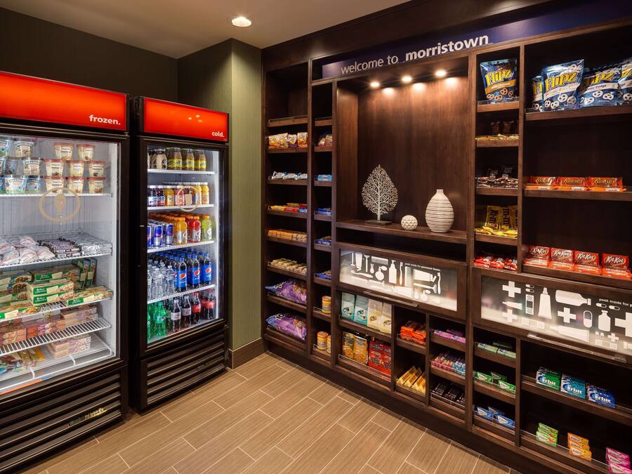 Una tienda de conveniencia bien surtida con secciones refrigeradas, estantes llenos de bocadillos y una gran variedad de bebidas.