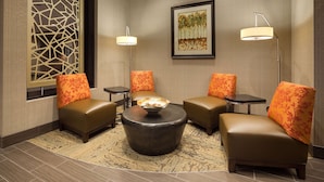 A modern lounge area with leather sofas, a round coffee table, and two floor lamps. - Hampton Inn Morristown, I-81 (Morristown)
