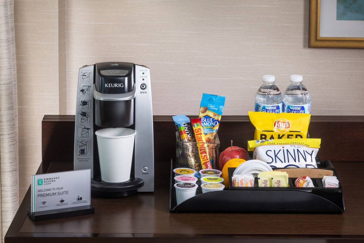 Une machine à café, des bouteilles d’eau, des en-cas et une pancarte indiquant une suite de luxe.