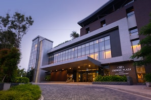 A modern hotel with a glass facade, a prominent entrance, and a sign reading "Crowne Plaza".