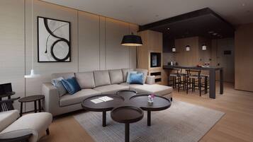 A modern living room with a sofa, coffee table, and a dining area with bar stools.