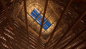 Un atrium con techos altos, una estructura de vigas de madera y tragaluces.