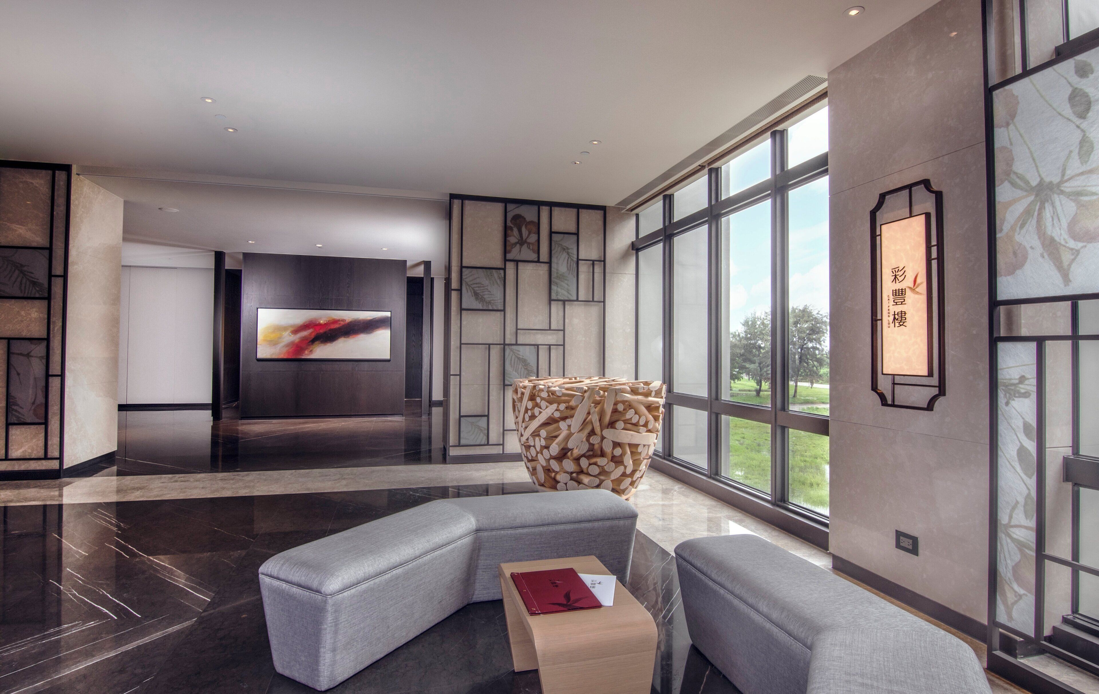 A modern living room with a sectional sofa, a wooden coffee table, and a large TV screen.