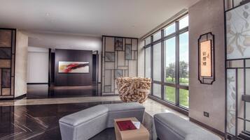 A modern living room with a sectional sofa, a wooden coffee table, and a large TV screen.