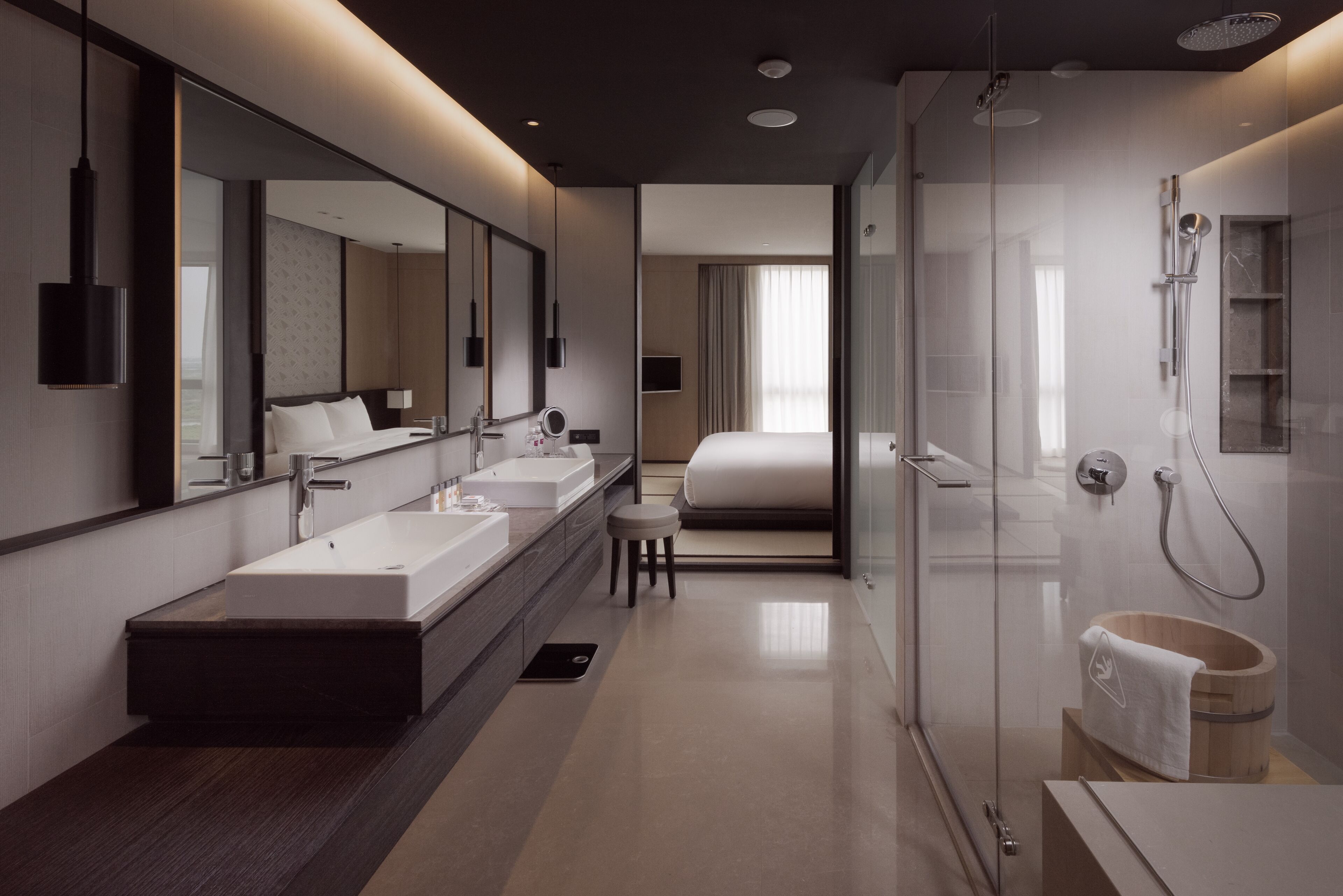 Ein modernes Hotelbad mit einem großen Spiegel, zwei Waschbecken, einer Dusche und einer Badewanne.