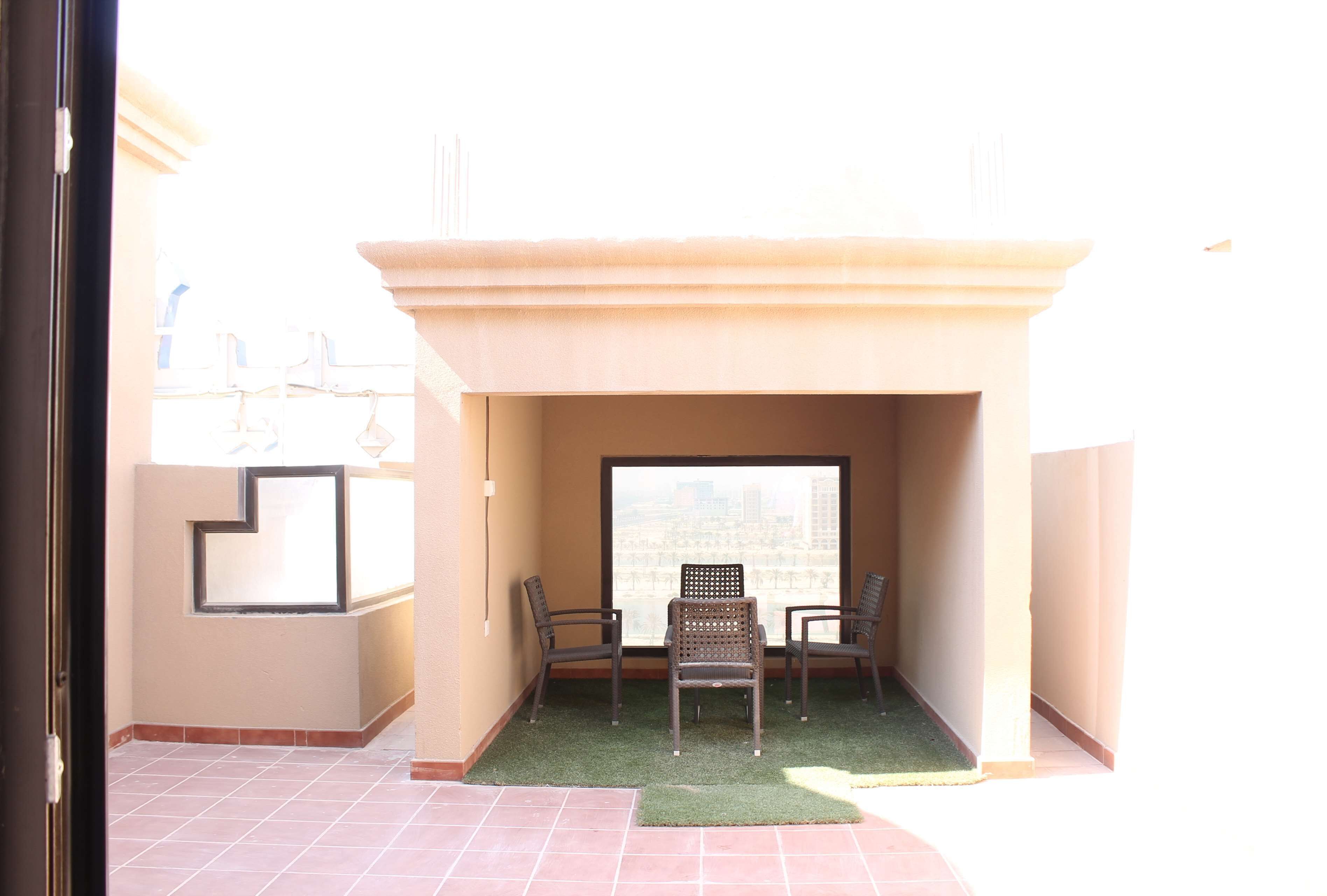 Un balcone con vista sulla città, un tavolino e due sedie.