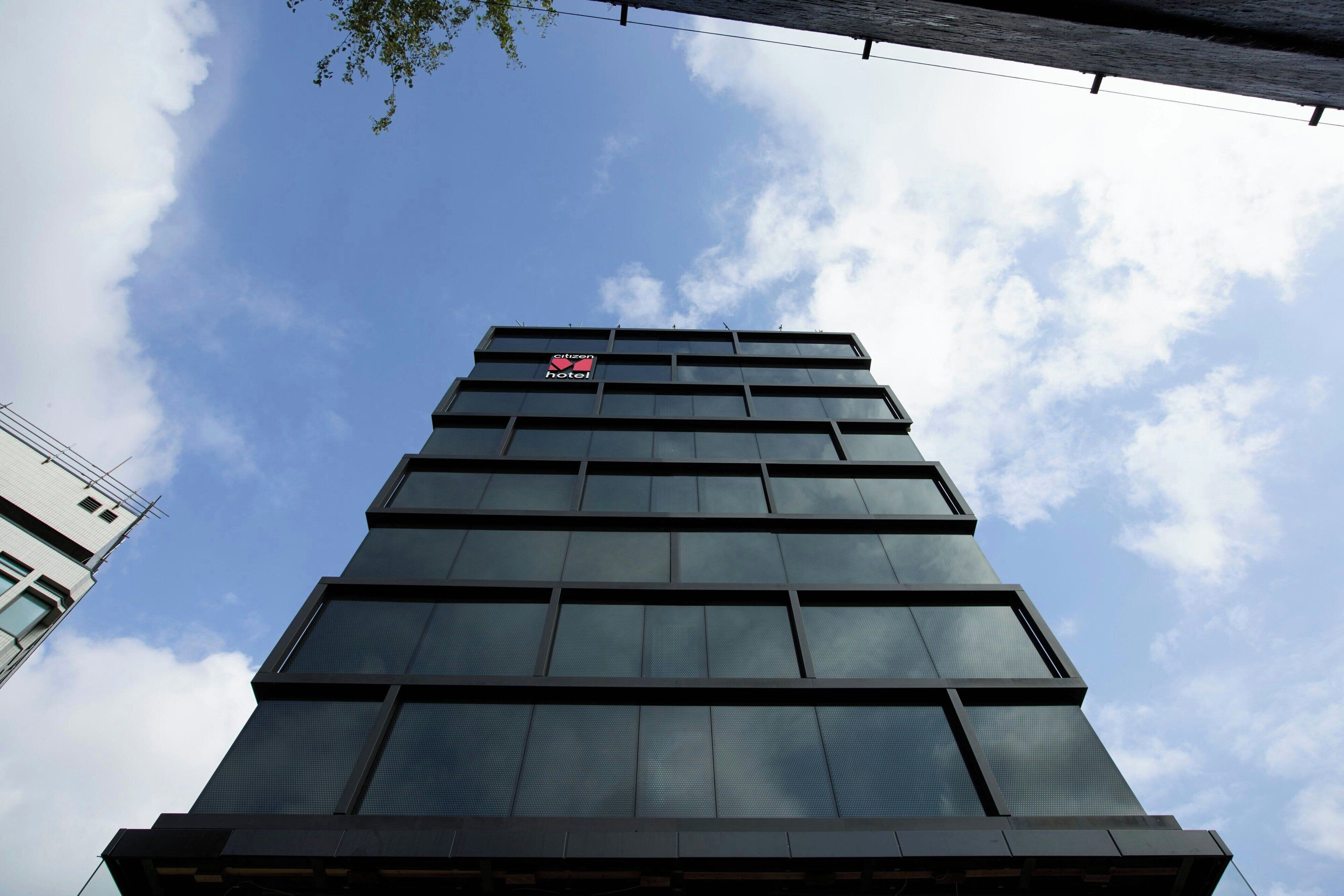 Un hotel de gran altura con fachada moderna de vidrio y un letrero visible que indica que es un hotel.
