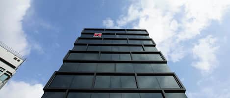A high-rise hotel with a modern glass facade and a visible sign indicating it is a hotel.
