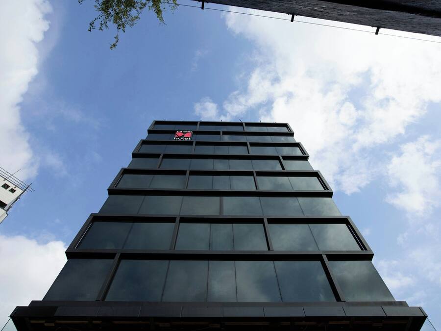 Un hotel de gran altura con fachada moderna de vidrio y un letrero visible que indica que es un hotel.