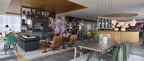A modern interior with a dining area, seating, and a bar.
