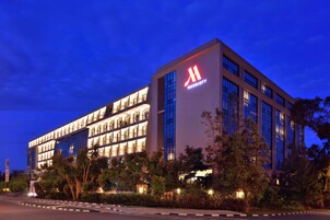 A modern hotel building with a prominent 'M' logo, multiple floors, and a well-lit facade.