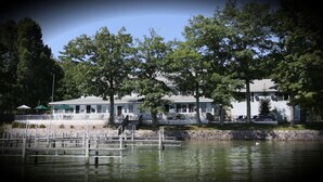 A lakeside property with multiple buildings, docks, and a stone wall. - Churchill Pointe Inn (Hubbard Lake)