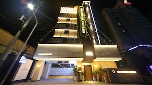 Un hotel con un letrero llamativo que dice "The Stone Bridge" y una fachada moderna con ventanas iluminadas.