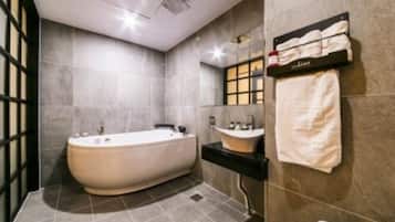 A modern bathroom with a freestanding bathtub, a vanity with a sink, and a towel rack.