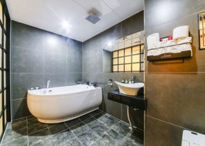 A modern bathroom with a freestanding bathtub, a vanity with a sink, and a towel rack on the wall. - Jeonju Lime Hotel (Jeonju)