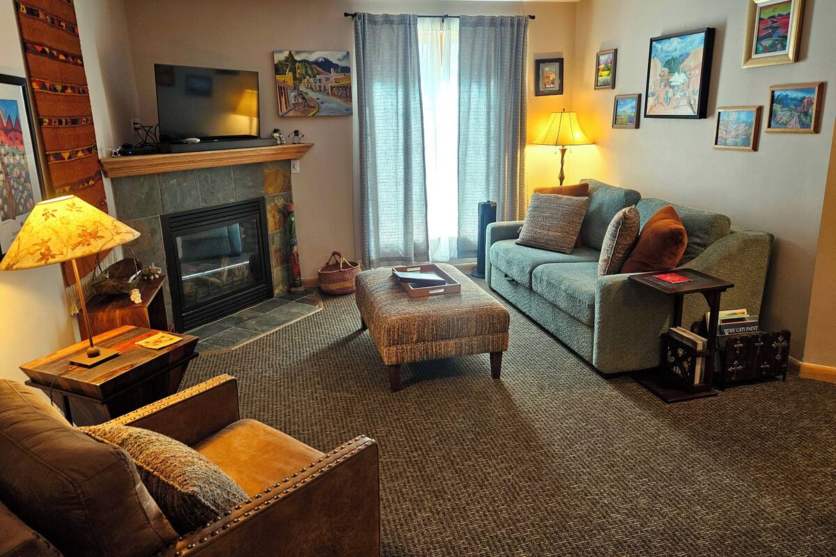 A living room with a fireplace, a sofa, a coffee table, and a television.