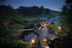 A traditional Japanese garden with a koi pond, stone pathway, and wooden structures. - Genryu no Yado Hozantei (Minamioguni)