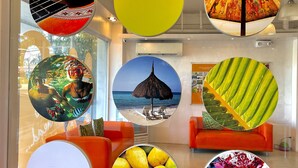 Een modern interieur met ronde ramen die verschillende beelden tonen, fel oranje zitplaatsen en een zichtbare airconditioning.