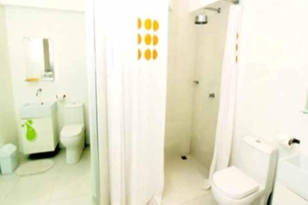 A bathroom with a toilet, sink, and shower area.