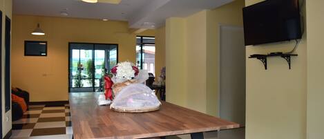 A modern dining area with a wooden table, benches, and a vase of flowers.