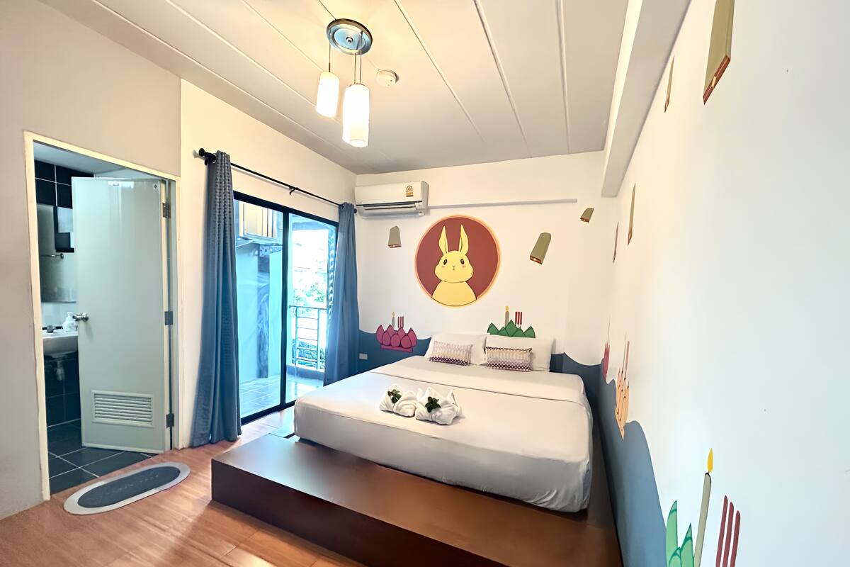 Une chambre avec un lit, une salle de bain et un balcon.