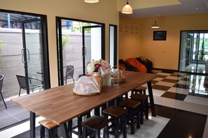 A modern interior with a wooden table, chairs, and a checkered floor. - Hide Bangkok Hostel (Bangkok)