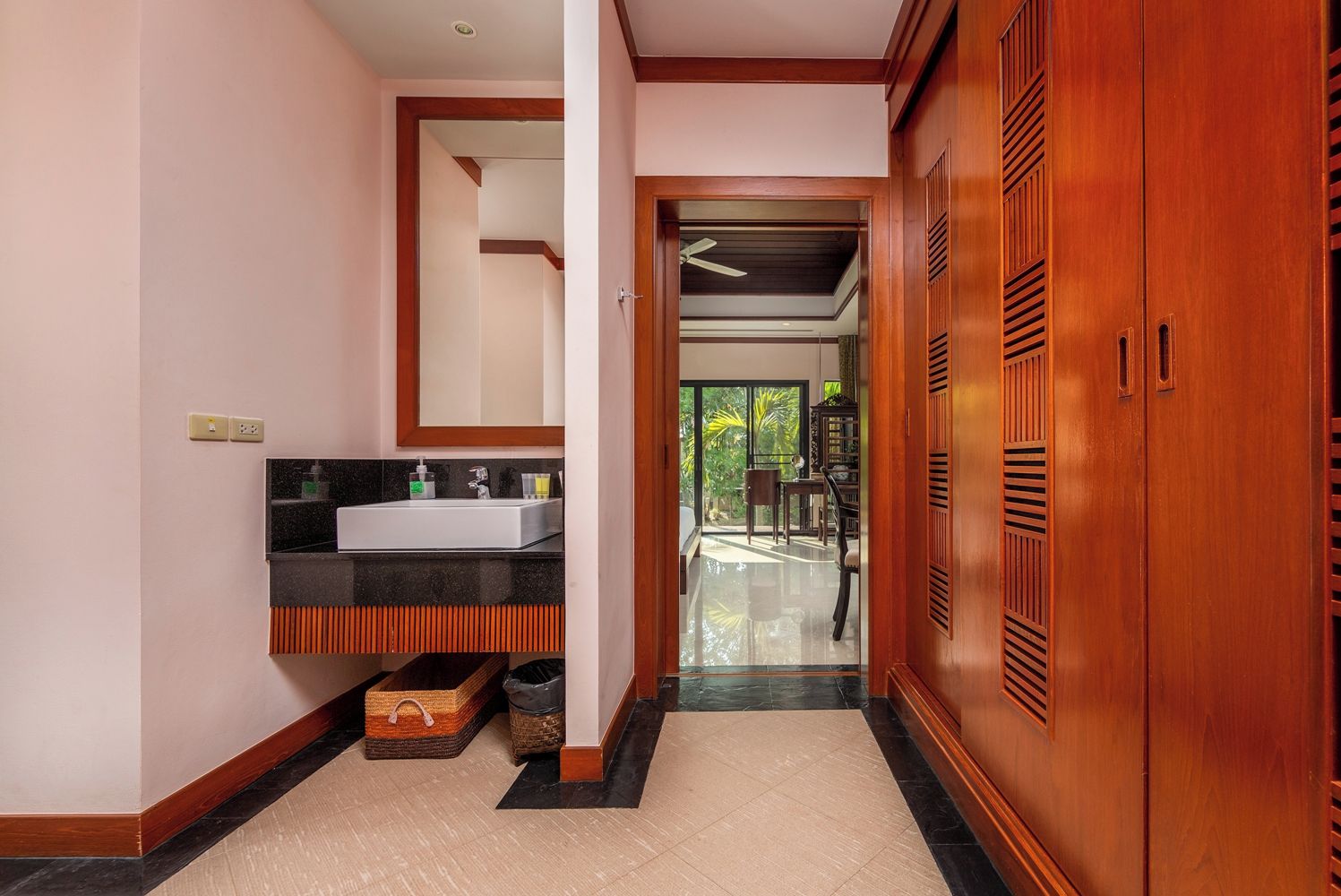 Une salle de bain moderne avec un grand lavabo, des meubles en bois et une vue sur un balcon.