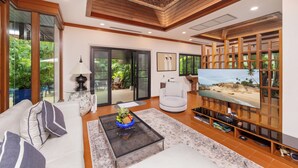 A modern living room with a sofa, coffee table, and TV stand. - Baan Bua Estate by Tropiclook (Rawai)