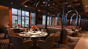 A modern dining area with round tables, chairs, and floral centerpieces. - Evergreen Laurel Hotel Shanghai (Shanghai)