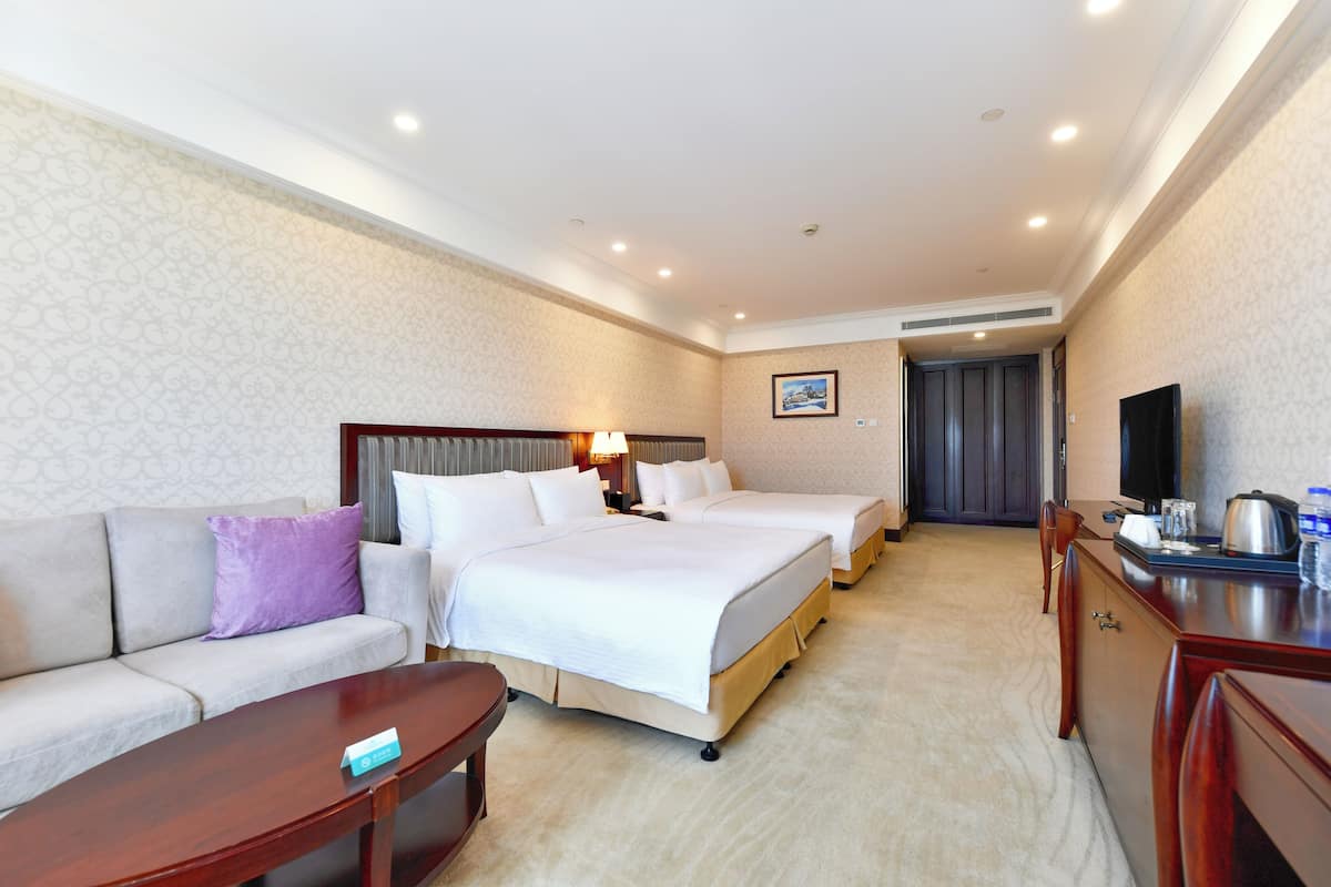 Een hotelkamer met een bed, een bank, een bureau en een televisie.